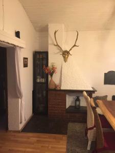 a room with a fireplace with a deer head on the wall at Ferienhaus Bussard in Gammelsbach