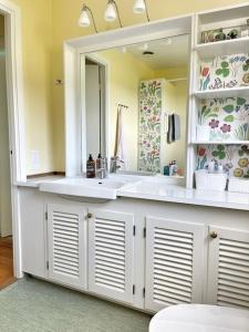un bagno con due lavandini e un grande specchio di Country house with sea view near Hovs Hallar a Båstad