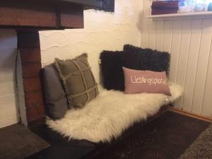 a couch with pillows on it next to a fireplace at Ferienhaus Bussard in Gammelsbach