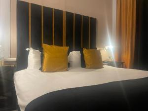 een slaapkamer met een bed met gele kussens bij Luxury 9ine Lush Jacuzzi Apartment with Balcony in Birmingham