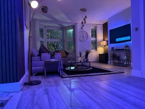un soggiorno viola con un divano e un tavolo di 1 Bed Flat - Sleeps 2 - Jacuzzi - Parking - Wifi a Birmingham