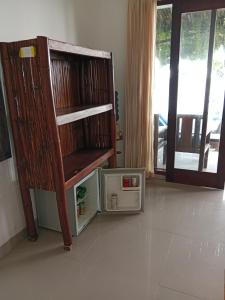 a room with a wooden shelf and a microwave at Kumpul Beach in Amed
