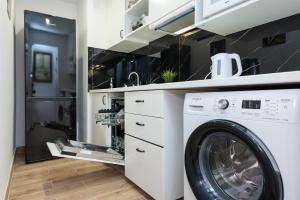 una lavanderia con lavatrice e asciugatrice di UnitApartament Warszawa Centrum Room in Apartment by Metro Rondo ONZ Super wygodne noclegi zapraszamy a Varsavia
