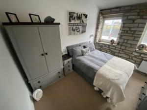 a bedroom with a bed and a brick wall at Robins mill in Rishworth