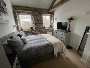 a bedroom with a bed and a television in it at Robins Mill in Rishworth