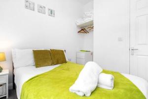 um quarto branco com uma cama com um cobertor verde em Emerald Suite Moseley Mews by StayStaycations em Birmingham
