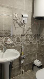 uma casa de banho com um lavatório branco e um espelho. em Gray Hotel em Lebedinovka