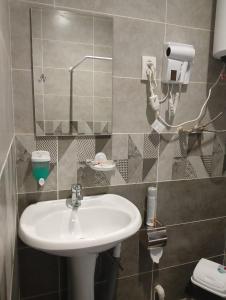 uma casa de banho com um lavatório e um espelho em Gray Hotel em Lebedinovka