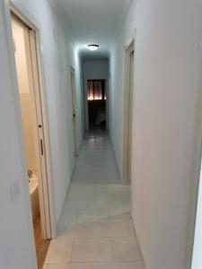 a hallway with white walls and a white tile floor at MAGNIFICO PISO JUNTO A PLAYA DE REGLA in Chipiona