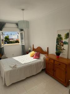 a bedroom with a bed and a dresser and a window at MAGNIFICO PISO JUNTO A PLAYA DE REGLA in Chipiona