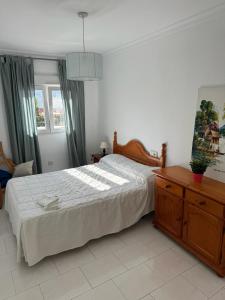 a bedroom with a bed and a dresser and a window at MAGNIFICO PISO JUNTO A PLAYA DE REGLA in Chipiona