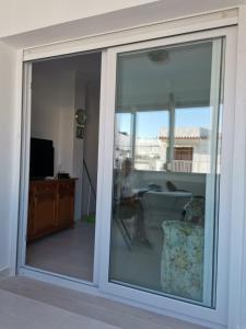 a sliding glass door in a room with a living room at MAGNIFICO PISO JUNTO A PLAYA DE REGLA in Chipiona