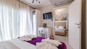 a bedroom with a bed with towels on it at Art Luxury Suites in Pefkohori