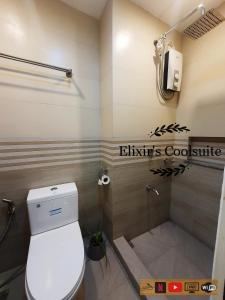 a bathroom with a toilet and a shower at Tagaytay affordable staycation by Elixir's Coolsuite in Tagaytay