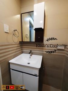a bathroom with a sink and a mirror at Tagaytay affordable staycation by Elixir's Coolsuite in Tagaytay