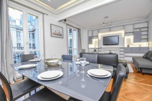 a dining room with a glass table and chairs at Charming appart 6P Trocadero in Paris