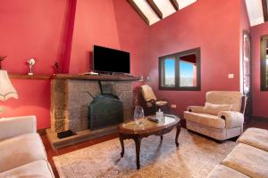 uma sala de estar com lareira e paredes vermelhas em Finca Madroñal em Santa Brígida