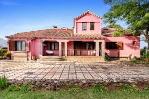 een roze huis met een tegeldak bij Finca Madroñal in Santa Brígida
