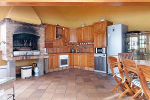 uma cozinha com armários de madeira e um frigorífico branco em Finca Madroñal em Santa Brígida