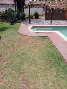 un patio trasero con piscina y mesa de picnic en Rizhatchguest, en Mahikeng