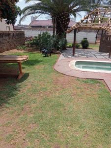 a backyard with a picnic table and a swimming pool at Rizhatchguest in Mahikeng