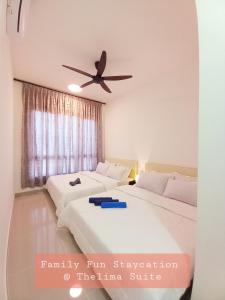 een slaapkamer met 2 bedden en een plafondventilator bij Family Fun Staycation @ Thelima Suite in Kajang