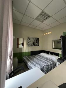 1 dormitorio con 2 camas y TV. en Monolocale Caraglio, en Turín