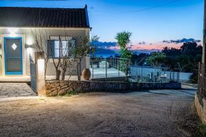 a house with a blue door and a balcony at Afrala Cottage in Khalikerí