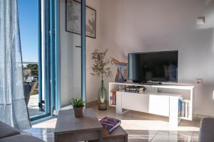 a living room with a tv and a white entertainment center at Afrala Cottage in Khalikerí