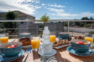 a table with breakfast foods and orange juice on a balcony at Afrala Cottage in Khalikerí