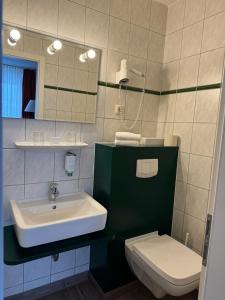 uma casa de banho com um lavatório e um WC em Mueßer Hof em Schwerin