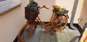 a bike with flowers in a basket next to a wall at Ferienwohnungen _ Haus Lisa_ in Senftenberg