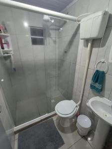 La salle de bains est pourvue d'une douche, de toilettes et d'un lavabo. dans l'établissement Casa de Praia Juli e Vini, à Cidreira