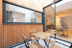 Un patio con una mesa y sillas de madera. en Fully equipped duplex with exterior and parking !, en Lille