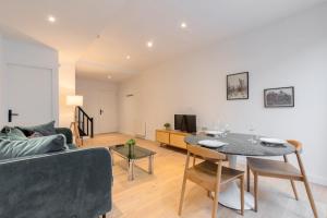 una sala de estar con un sofá y una mesa en Fully equipped duplex with exterior and parking !, en Lille