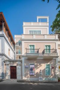 a white building with balconies on the side of it at Villa Kouga in Puducherry