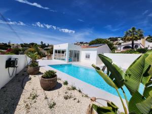 a swimming pool in the backyard of a house at Villa Blue Lagoon Moraira in Moraira