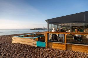 a restaurant on a beach with the ocean in the background at Stylish Southsea Retreat in Portsmouth