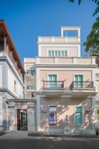 - un bâtiment blanc avec des balcons sur le côté dans l'établissement Villa Kouga, à Pondichéry