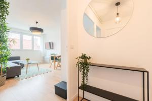 een woonkamer met een tv en een spiegel bij Lille, fully-equipped apartment with parking space in Lille