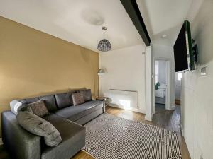 a living room with a couch and a tv at Stylish Southsea Retreat in Portsmouth