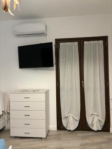 a bedroom with a dresser and a tv and a window at Vincent’s House in Mazara del Vallo