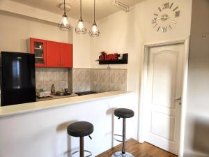 uma cozinha com dois bancos e um relógio na parede em Sunny em Belgrado