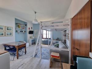 a bedroom with a bunk bed with a desk and a table at Apartment camelie with private beach in Baveno