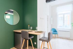 a dining room with green walls and a table and chairs at Character apartment in the heart of Old Lille in Lille