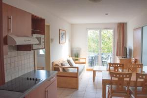 a kitchen and living room with a couch and a table at Residence Le Royal Golf & Horse in Mooslargue