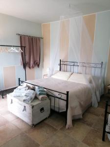 a bedroom with a large bed with a wooden chest at Casale Cavatella in Sermoneta