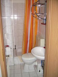 a small bathroom with a toilet and a sink at Pension Regenbogen in Stralsund