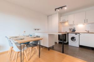 een keuken met een tafel en een wasmachine bij Spacious apartment with parking and balcony! in Lille