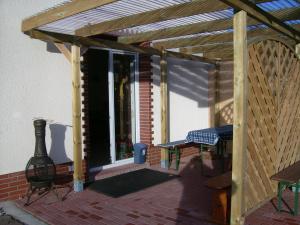 a wooden pergola with a picnic table on a patio at Pension Regenbogen in Stralsund
